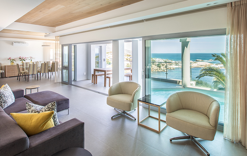 A room with a view! The living area on the middle level boasts a lounge and dining area. Look out onto the pool and patio, with the ocean stretching out beyond to the horizon. You’ll want to spend your time surrounded by the luxury this space brings!