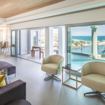 A room with a view! The living area on the middle level boasts a lounge and dining area. Look out onto the pool and patio, with the ocean stretching out beyond to the horizon. You’ll want to spend your time surrounded by the luxury this space brings!